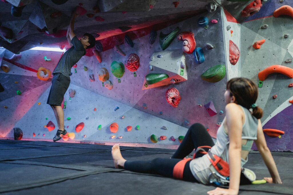 Asian man in climbing gym with girlfriend